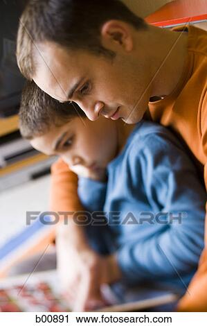 Stock Image - Profile of a father teaching his son. Fotosearch