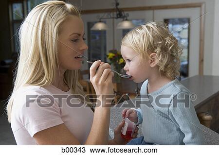 Side profile of a mother feeding her daughter with a spoon View Large Photo Image Stock Image - Side profile of a mother feeding her daughter with a spoon. Fotosearch