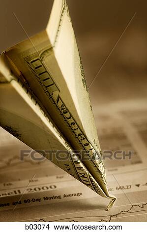 Picture - Close-up of a paper airplane made from one hundred dollar bill with damaged nose. Fotosearch