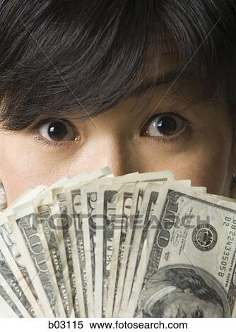 Portrait of a mid adult woman fanning bills in front of her face View Large Photo Image Stock Photography - Portrait of a mid adult woman fanning bills in front of her face. Fotosearch