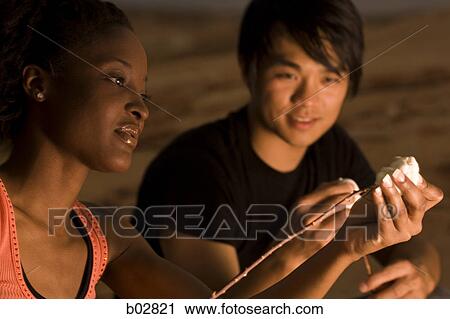 Close-up of a young woman putting marshmallows on a stick View Large Photo Image Stock Image - Close-up of a young woman putting marshmallows on a stick. Fotosearch