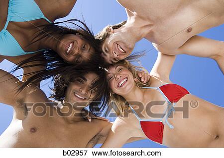 Stock Photo - Four young people at the beach. Fotosearch