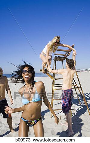 Four young people on the beach View Large Photo Image Stock Image - Four young people on the beach. Fotosearch