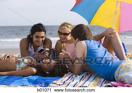 Four young people on the beach View Large Photo Image Stock Image - Four young people on the beach. Fotosearch