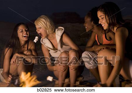 Four young women sitting at a campfire View Large Photo Image Stock Photography - Four young women sitting at a campfire. Fotosearch