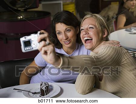 High angle view of two women taking a photograph of themselves View Large Photo Image Stock Image - High angle view of two women taking a photograph of themselves. Fotosearch