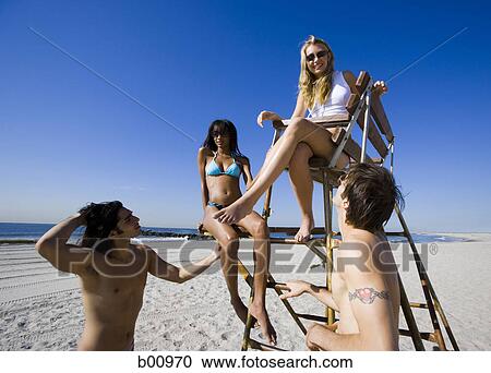 Low angle view of four young people on the beach View Large Photo Image Stock Image - Low angle view of four young people on the beach. Fotosearch