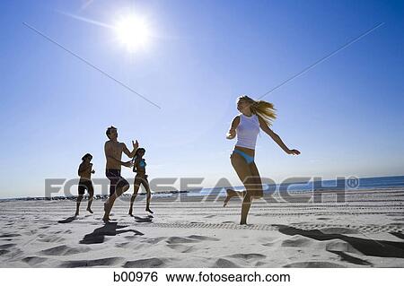 Low angle view of four young people running on the beach View Large Photo Image Stock Photograph - Low angle view of four young people running on the beach. Fotosearch