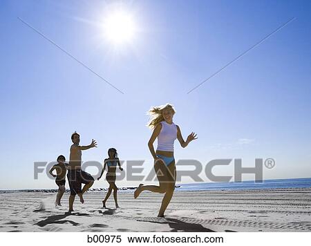 Low angle view of four young people running on the beach View Large Photo Image Stock Photography - Low angle view of four young people running on the beach. Fotosearch