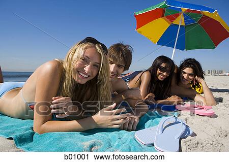 Portrait of four young people lying on the beach View Large Photo Image Stock Image - Portrait of four young people lying on the beach. Fotosearch