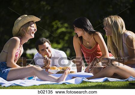 Three young women with a young man enjoying in a park View Large Photo Image Stock Photography - Three young women with a young man enjoying in a park. Fotosearch