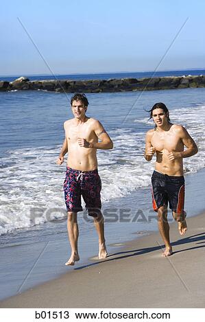 Two young men running on the beach View Large Photo Image Stock Image - Two young men running on the beach. Fotosearch