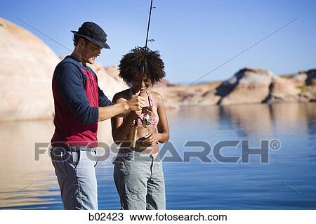 Young man teaching a young woman how to fish View Large Photo Image Stock Image - Young man teaching a young woman how to fish. Fotosearch