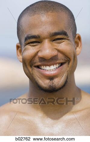 Close-up of a young man smiling View Large Photo Image Stock Image - Close-up of a young man smiling. Fotosearch