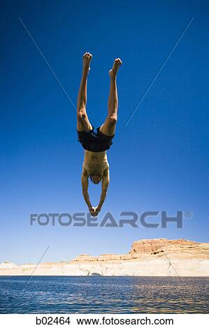 Low angle view of a young man jumping in water View Large Photo Image Picture - Low angle view of a young man jumping in water. Fotosearch