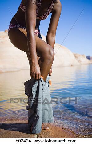 Picture - Low angle view of a young woman dressing up. Fotosearch