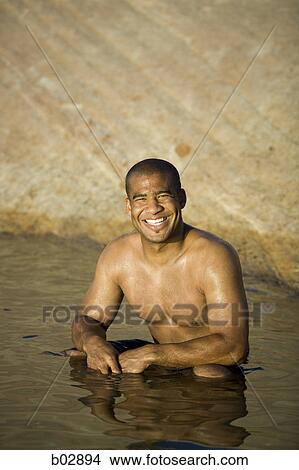 Portrait of a young man sitting in a lake View Large Photo Image Picture - Portrait of a young man sitting in a lake. Fotosearch