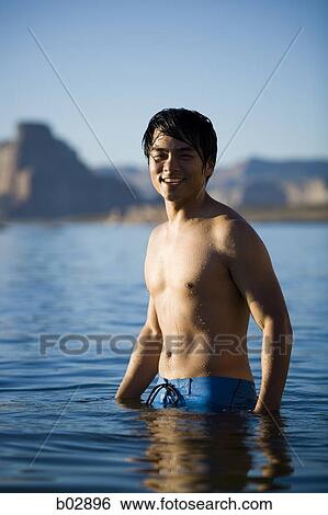 Portrait of a young man standing in a lake View Large Photo Image Stock Photograph - Portrait of a young man standing in a lake. Fotosearch