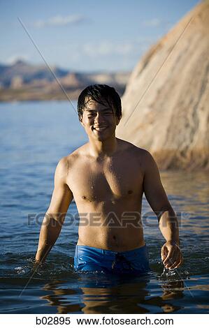Portrait of a young man wading in a lake View Large Photo Image Stock Photography - Portrait of a young man wading in a lake. Fotosearch