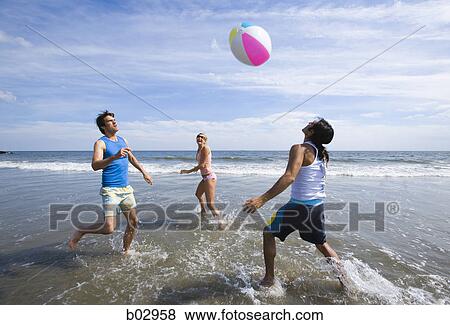 Stock Photo - Three young people at the beach. Fotosearch
