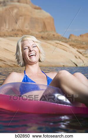 Young woman sitting in an inflatable raft View Large Photo Image Stock Image - Young woman sitting in an inflatable raft. Fotosearch