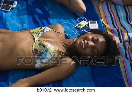 High angle view of a young woman lying on a beach towel View Large Photo Image Stock Image - High angle view of a young woman lying on a beach towel. Fotosearch
