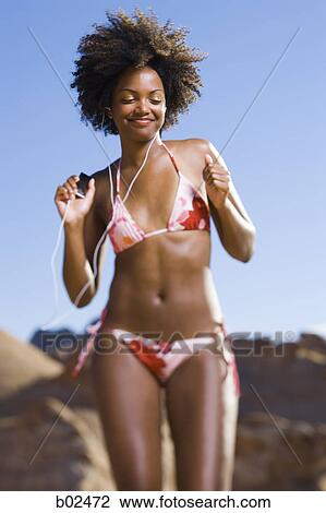 Low angle view of a young woman dancing with listening to an MP3 Player View Large Photo Image Stock Image - Low angle view of a young woman dancing with listening to an MP3 Player. Fotosearch