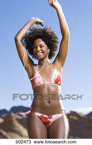 Low angle view of a young woman dancing with listening to an MP3 Player View Large Photo Image Stock Image - Low angle view of a young woman dancing with listening to an MP3 Player. Fotosearch
