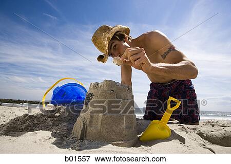 Portrait of a young man showing a seashell on the beach View Large Photo Image Stock Photo - Portrait of a young man showing a seashell on the beach. Fotosearch