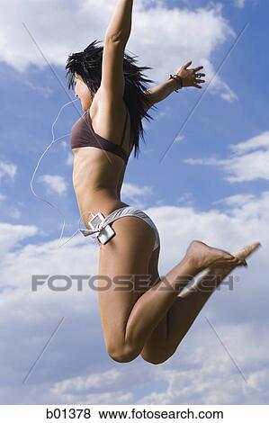 Profile of a young woman jumping in air View Large Photo Image Stock Photo - Profile of a young woman jumping in air. Fotosearch