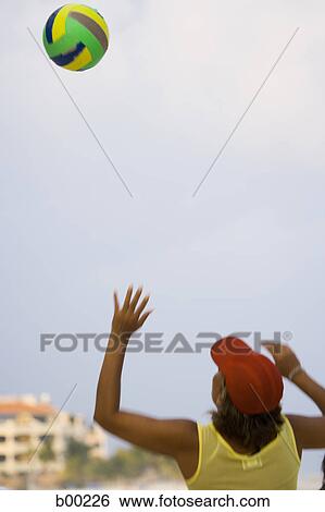 Rear view of a woman playing beach volleyball View Large Photo Image Stock Photograph - Rear view of a woman playing beach volleyball. Fotosearch