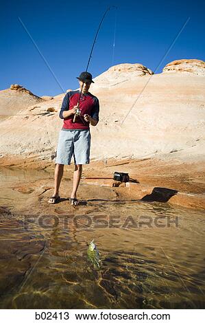 Stock Image - Young man fishing. Fotosearch