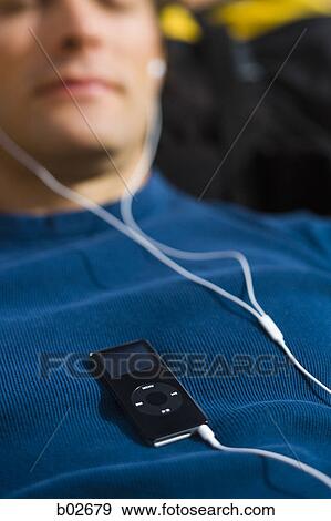 Close-up of a young man listening to an MP3 Player View Large Photo Image Stock Photo - Close-up of a young man listening to an MP3 Player. Fotosearch