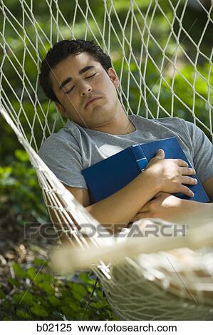 High angle view of a young man sleeping in hammock View Large Photo Image Stock Photography - High angle view of a young man sleeping in hammock. Fotosearch