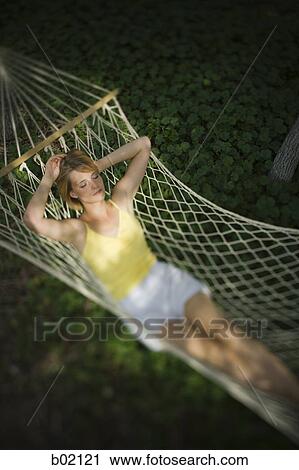 High angle view of a young woman relaxing in a hammock View Large Photo Image Stock Image - High angle view of a young woman relaxing in a hammock. Fotosearch