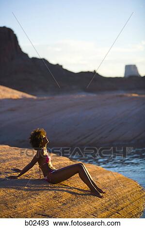 High angle view of a young woman sitting on a rock View Large Photo Image Stock Image - High angle view of a young woman sitting on a rock. Fotosearch