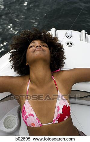 High angle view of a young woman resting on a speed boat View Large Photo Image Stock Photography - High angle view of a young woman resting on a speed boat. Fotosearch