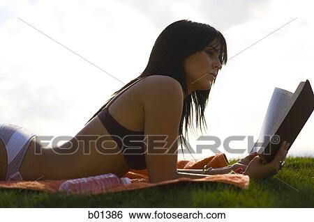 Stock Photograph - Profile of a young woman reading. Fotosearch