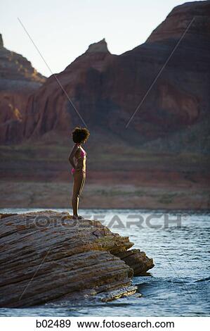 Profile of a young woman standing on a rock View Large Photo Image Stock Photo - Profile of a young woman standing on a rock. Fotosearch