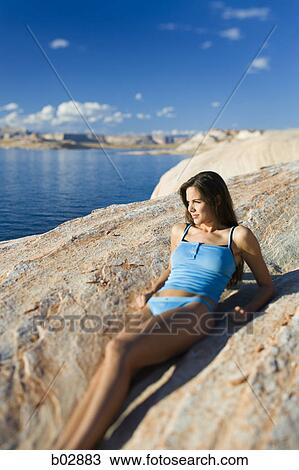 Young woman lying on a rock View Large Photo Image Stock Image - Young woman lying on a rock. Fotosearch