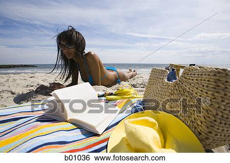 Stock Photograph - Young woman lying on the beach. Fotosearch