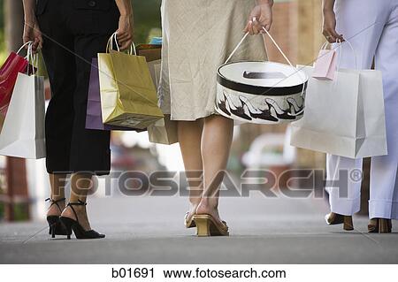 Low section view of three women walking on a sidewalk View Large Photo Image Stock Image - Low section view of three women walking on a sidewalk. Fotosearch