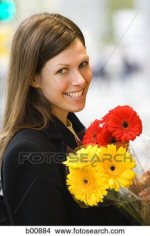 Picture - Portrait of a young woman holding a bouquet of flowers. Fotosearch