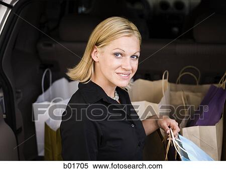 Portrait of a young woman holding shopping bags View Large Photo Image Stock Photography - Portrait of a young woman holding shopping bags. Fotosearch