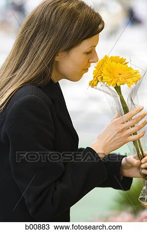 Profile of a young woman smelling a bunch of flowers View Large Photo Image Stock Image - Profile of a young woman smelling a bunch of flowers. Fotosearch