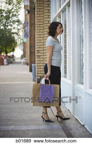 Profile of an adult woman looking at a window display View Large Photo Image Stock Photo - Profile of an adult woman looking at a window display. Fotosearch