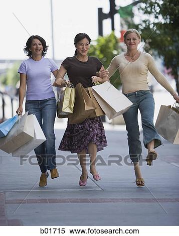 Stock Photography - Three women carrying shopping bags. Fotosearch