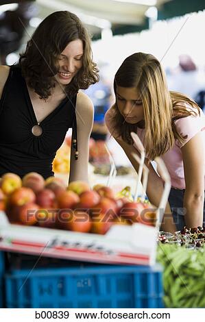 Stock Photo - Two teenage girls at a fruit stand. Fotosearch