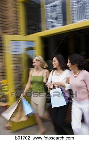 Two young women with an adult woman stepping out of a store View Large Photo Image Stock Image - Two young women with an adult woman stepping out of a store. Fotosearch