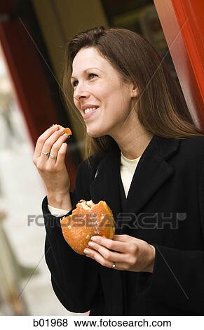Young woman eating a sandwich View Large Photo Image Stock Photo - Young woman eating a sandwich. Fotosearch